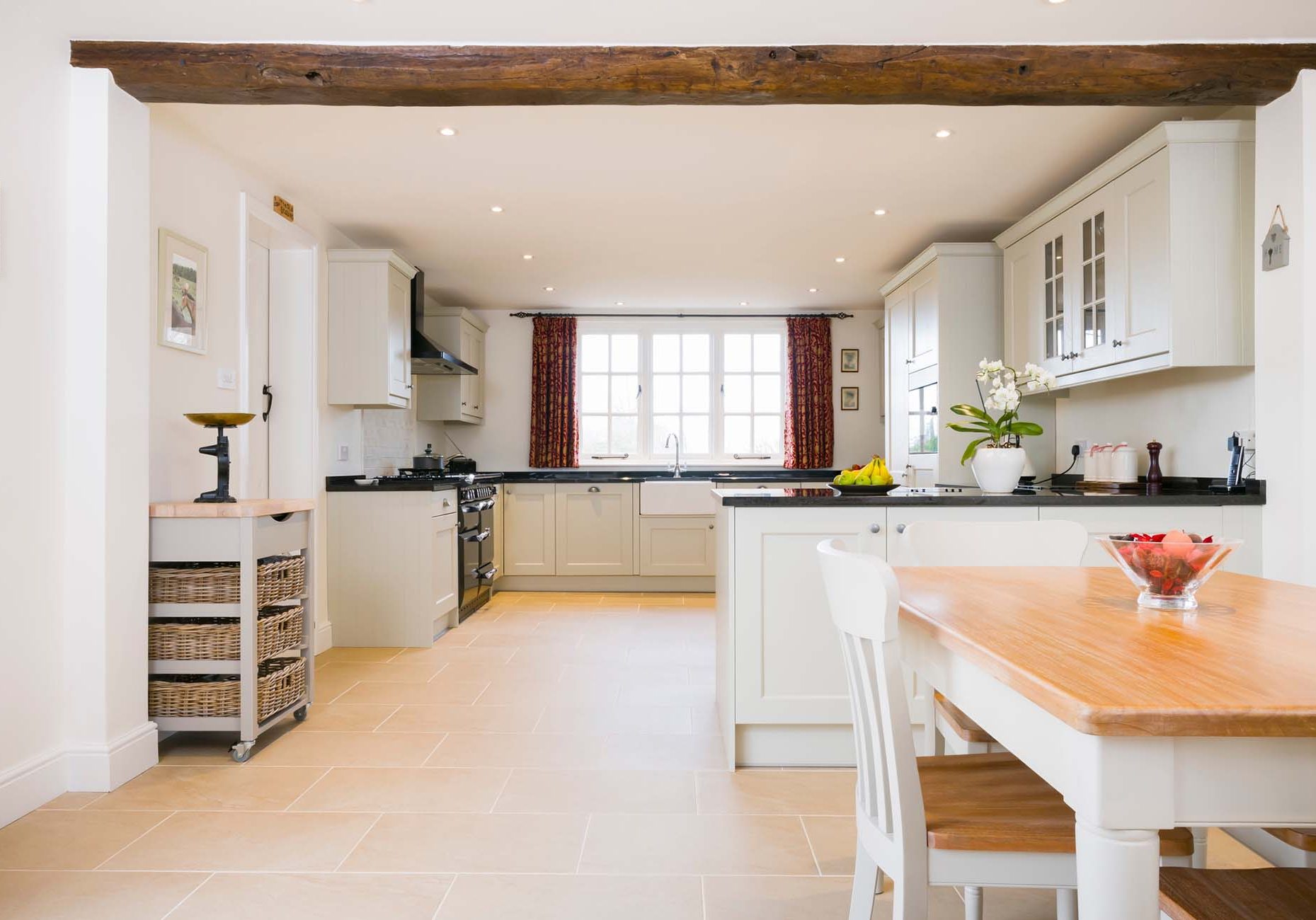 Open plan farmhouse kitchen dining room, with modern painted wood modular kitchen units, UK interior design